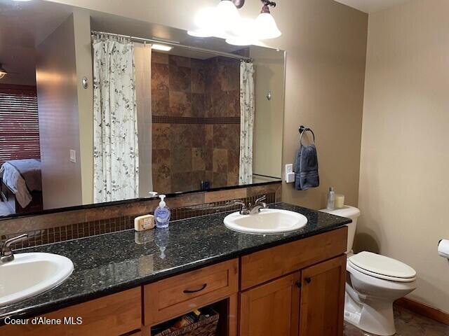 bathroom with a shower with curtain, vanity, and toilet