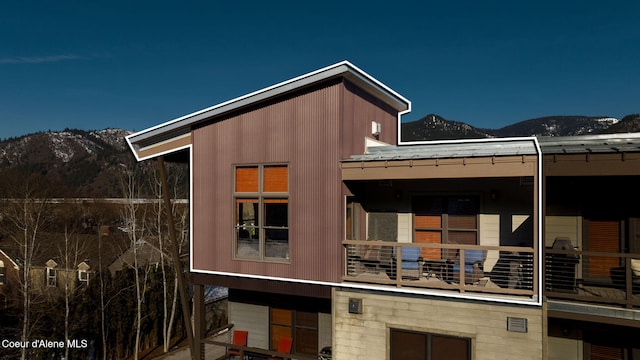 rear view of property with a balcony and a mountain view