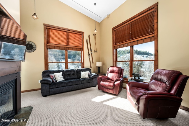 carpeted living room with a healthy amount of sunlight and high vaulted ceiling