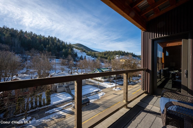 snow covered back of property featuring a mountain view