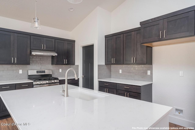 kitchen featuring pendant lighting, stainless steel gas stove, tasteful backsplash, and sink