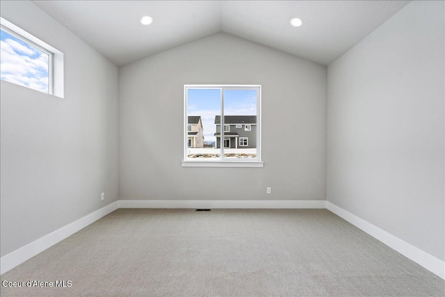 unfurnished room with carpet flooring, a healthy amount of sunlight, and lofted ceiling