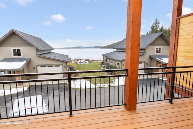 wooden deck with a water and mountain view