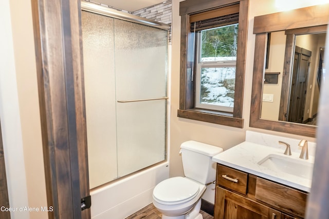 full bathroom featuring vanity, toilet, and shower / bath combination with glass door