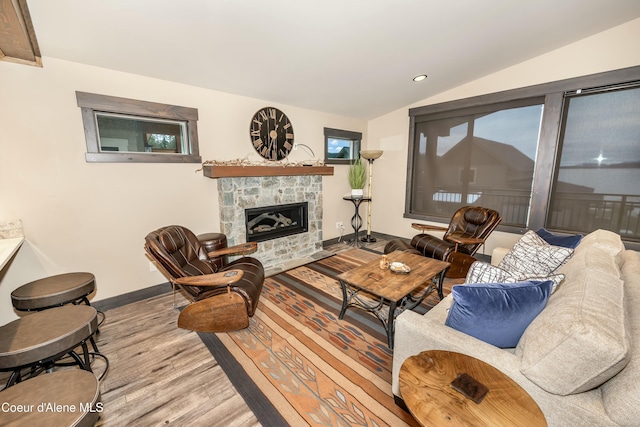 living room featuring a fireplace, hardwood / wood-style floors, and vaulted ceiling