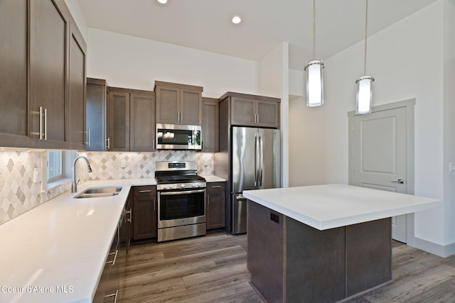 kitchen with a kitchen island, dark hardwood / wood-style flooring, pendant lighting, and stainless steel appliances