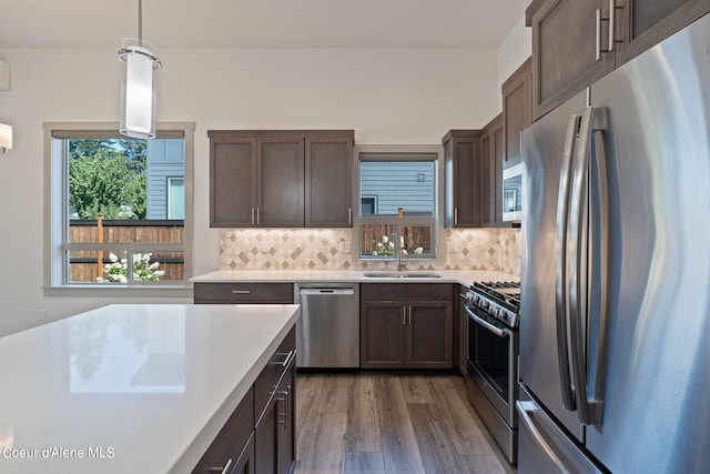 kitchen with sink, decorative light fixtures, appliances with stainless steel finishes, and backsplash