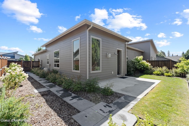 back of house featuring a patio area and a yard