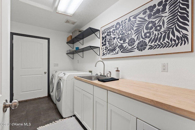 laundry room with washer and clothes dryer, sink, and cabinets