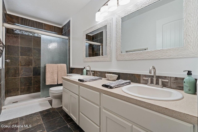 bathroom featuring vanity, toilet, and a shower with shower door