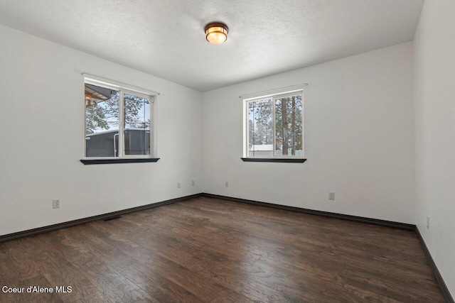 spare room with dark hardwood / wood-style flooring and a textured ceiling