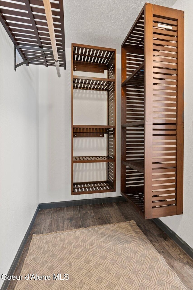 wine room featuring wood-type flooring and a textured ceiling