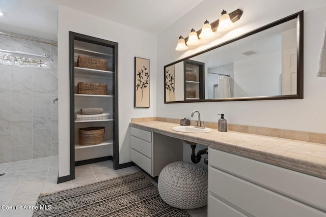 bathroom with tile patterned floors, curtained shower, and vanity