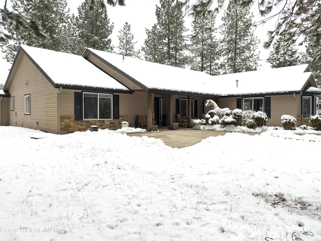 view of snow covered back of property