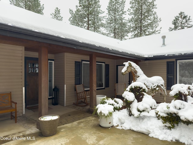 snow covered property with a porch