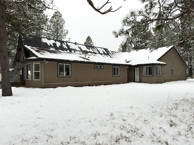 view of snow covered rear of property