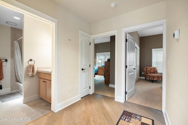 bathroom featuring hardwood / wood-style floors, plenty of natural light, vanity, and shower / tub combo