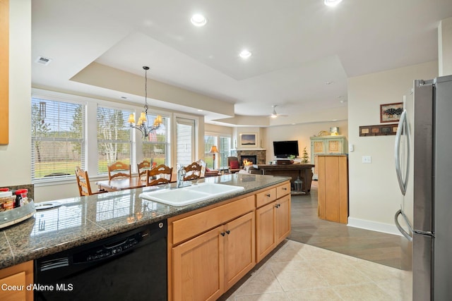 kitchen featuring sink, black dishwasher, stainless steel fridge, decorative light fixtures, and light tile patterned floors