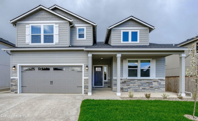 craftsman-style home with a front yard, a garage, and covered porch