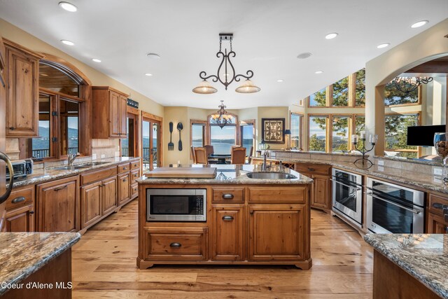 13277 S Ridgeview Loop, Harrison, ID 83833 - kitchen featuring appliances with stainless steel finishes, an island with sink, recessed lighting, light wood-style flooring, and pendant lighting