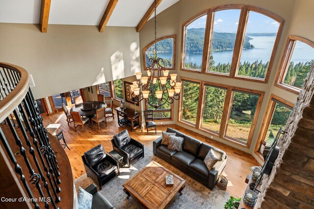 13277 S Ridgeview Loop, Harrison, ID 83833 - living room with wood finished floors, a towering ceiling, a water view, beamed ceiling, and a chandelier