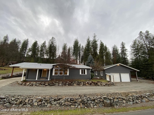 single story home with covered porch, an outbuilding, and a garage