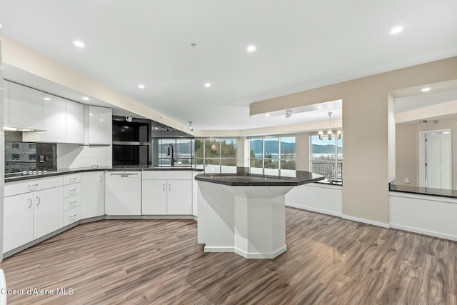 kitchen with dishwasher, hardwood / wood-style floors, tasteful backsplash, and white cabinetry