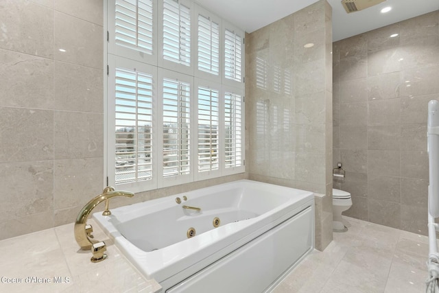 bathroom with tile patterned flooring, toilet, tile walls, and a bathing tub