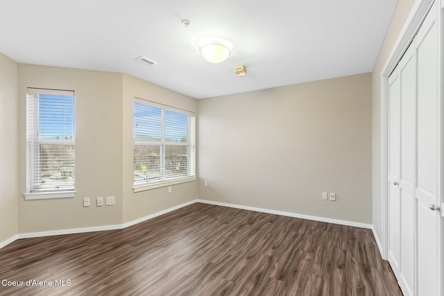 unfurnished bedroom with a closet and dark wood-type flooring