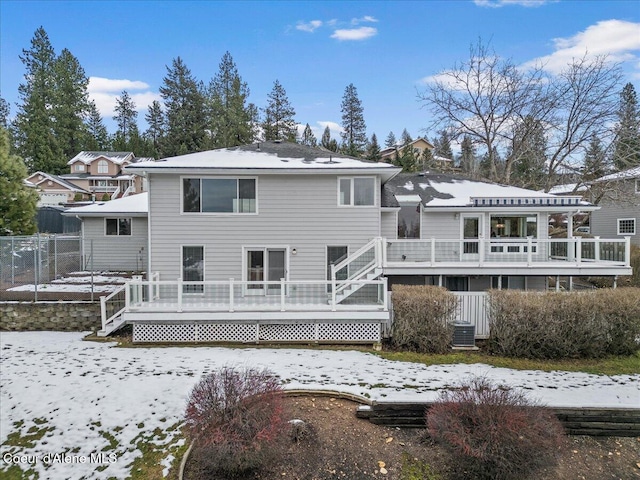 snow covered rear of property with a deck and central AC unit