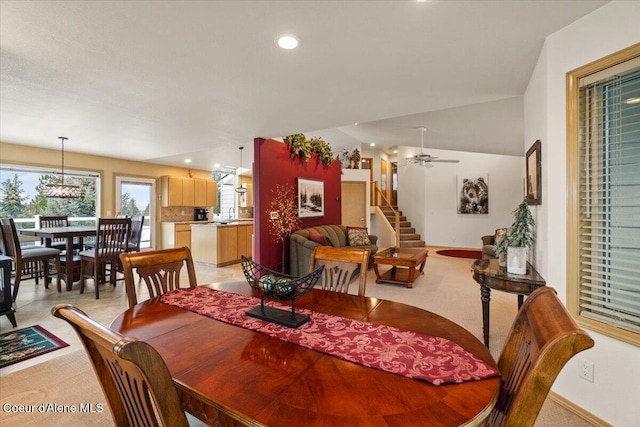 carpeted dining room with ceiling fan and vaulted ceiling