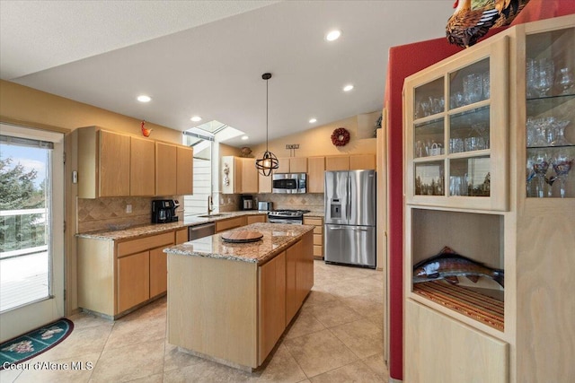 kitchen featuring appliances with stainless steel finishes, sink, decorative light fixtures, a kitchen island, and lofted ceiling