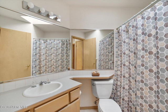 bathroom featuring decorative backsplash, vanity, and toilet