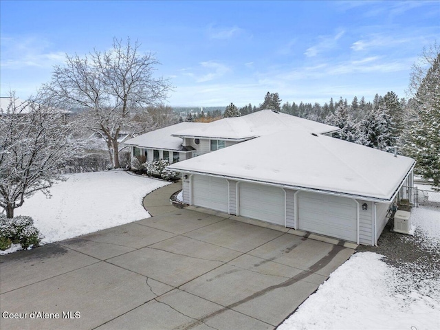 snow covered property with a garage