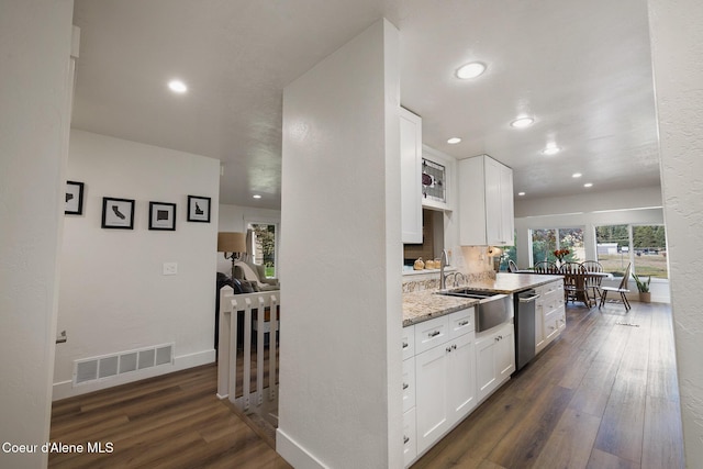 kitchen with white cabinetry, dishwasher, light stone counters, and sink