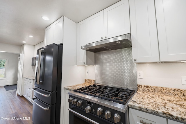 kitchen featuring dark hardwood / wood-style floors, white cabinetry, stainless steel appliances, and light stone counters