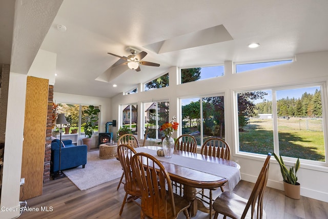 dining area with ceiling fan, hardwood / wood-style floors, and vaulted ceiling