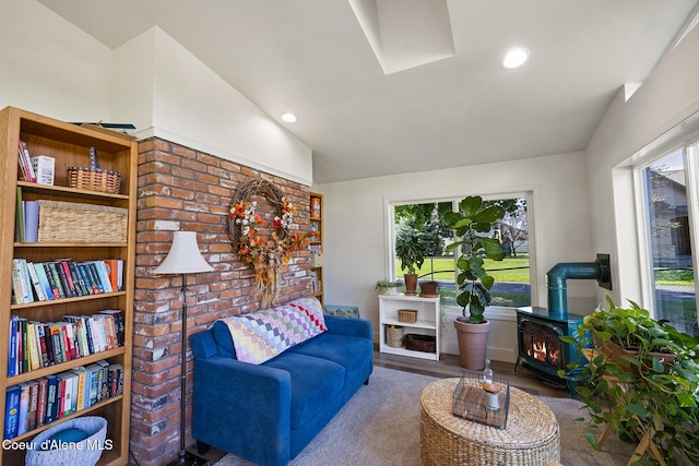 living room with a wood stove, hardwood / wood-style floors, and vaulted ceiling