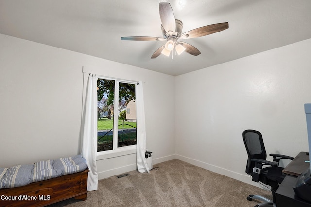 carpeted office featuring ceiling fan