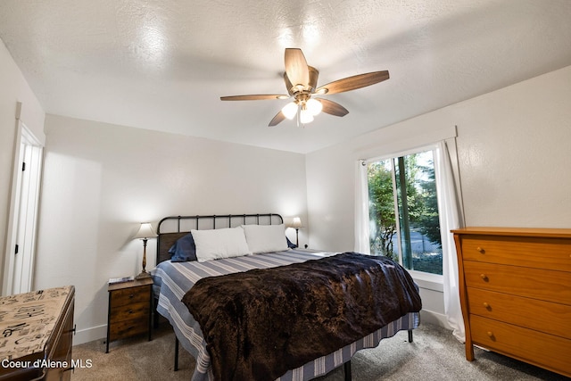 carpeted bedroom with a textured ceiling and ceiling fan