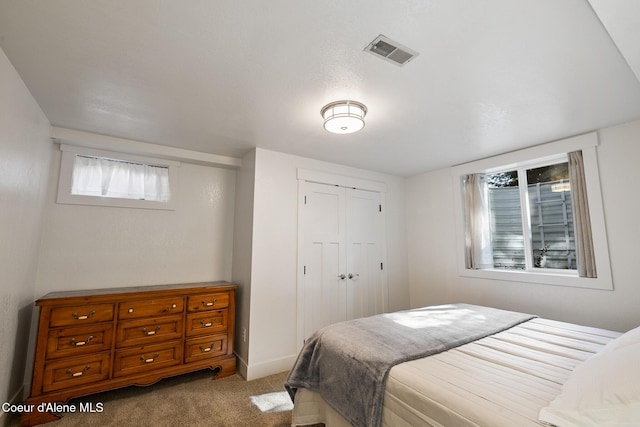 bedroom featuring light colored carpet, multiple windows, and a closet