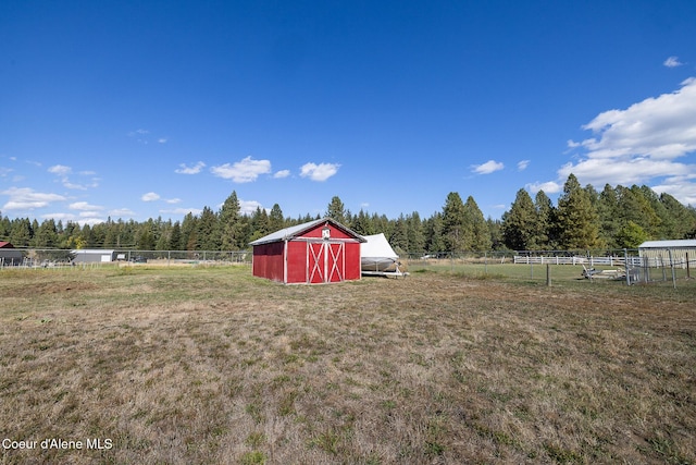 view of yard with a rural view and an outbuilding