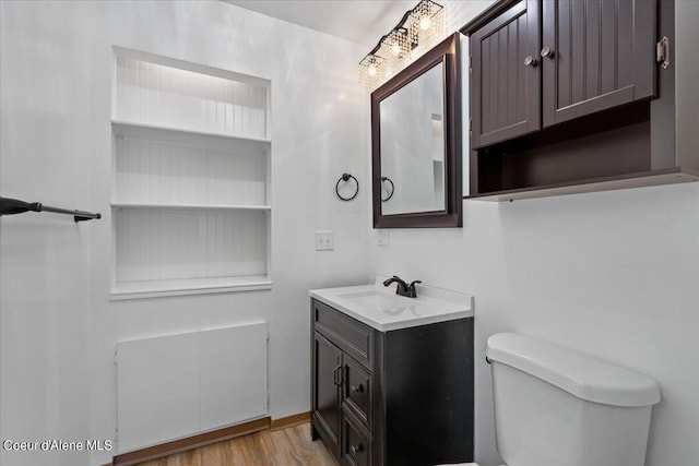 bathroom with hardwood / wood-style flooring, vanity, and toilet