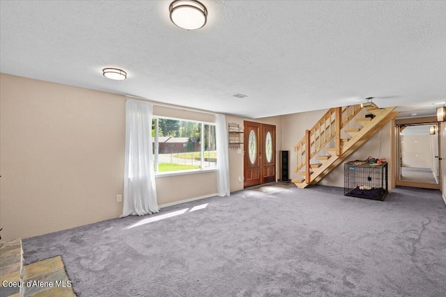 unfurnished living room featuring carpet and a textured ceiling