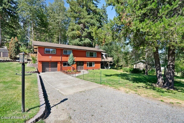 bi-level home featuring a garage and a front lawn