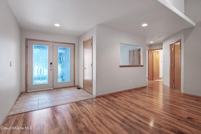 foyer entrance featuring light hardwood / wood-style flooring and french doors