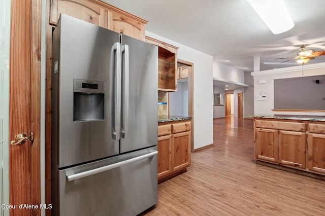 kitchen featuring light stone countertops, tasteful backsplash, ceiling fan, stainless steel fridge with ice dispenser, and light hardwood / wood-style floors