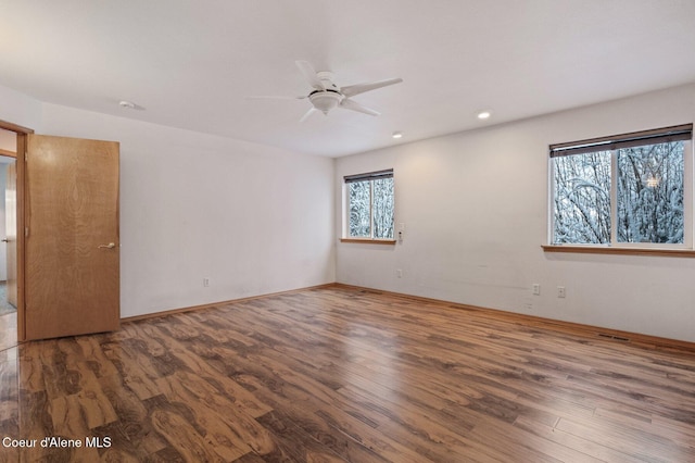 unfurnished room with ceiling fan and dark wood-type flooring