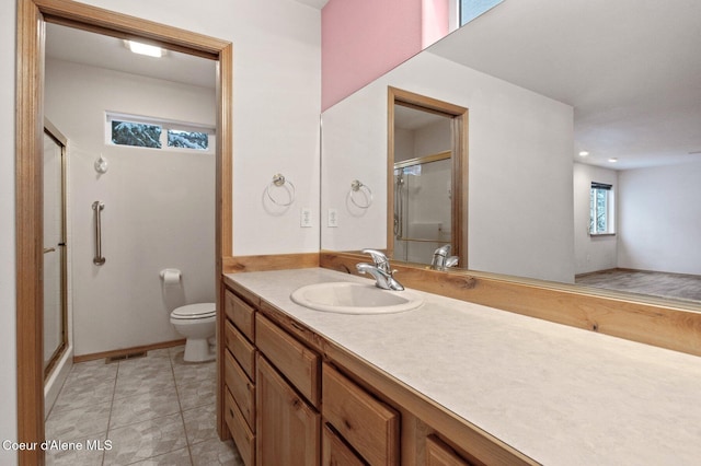 bathroom with vanity, a shower with shower door, and toilet