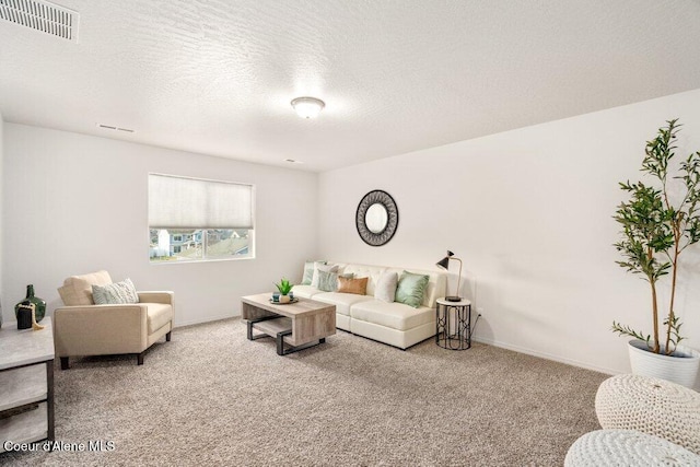 carpeted living room featuring a textured ceiling